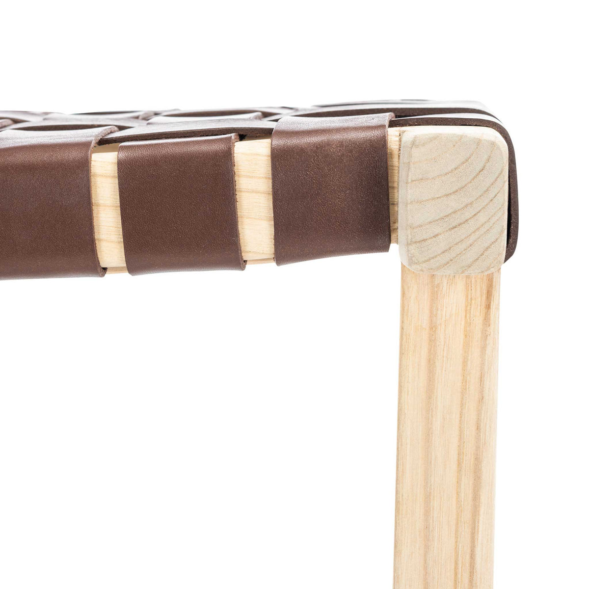 Cognac leather bands fold over a light wood seat rail beside a softly grained corner post