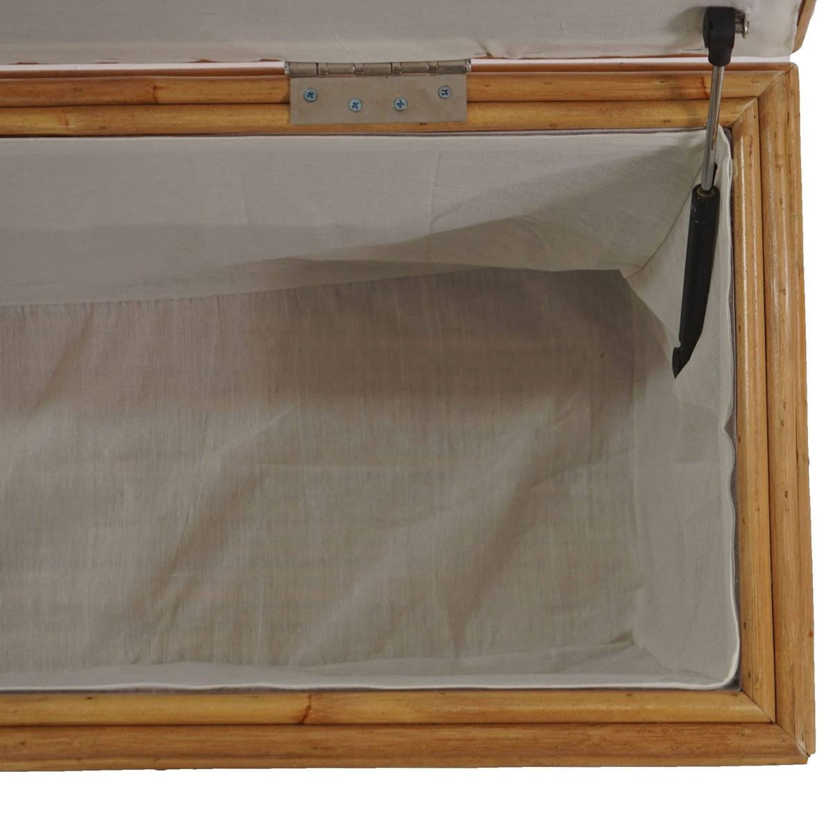Soft fabric lining and a metal lid support add practical detail to the roomy rattan trunk interior.