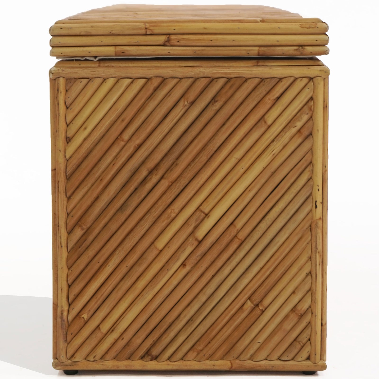 Closely spaced diagonal rattan slats fill the trunk's narrow end beneath a rounded, layered lid. || CWK3032A || side_studio