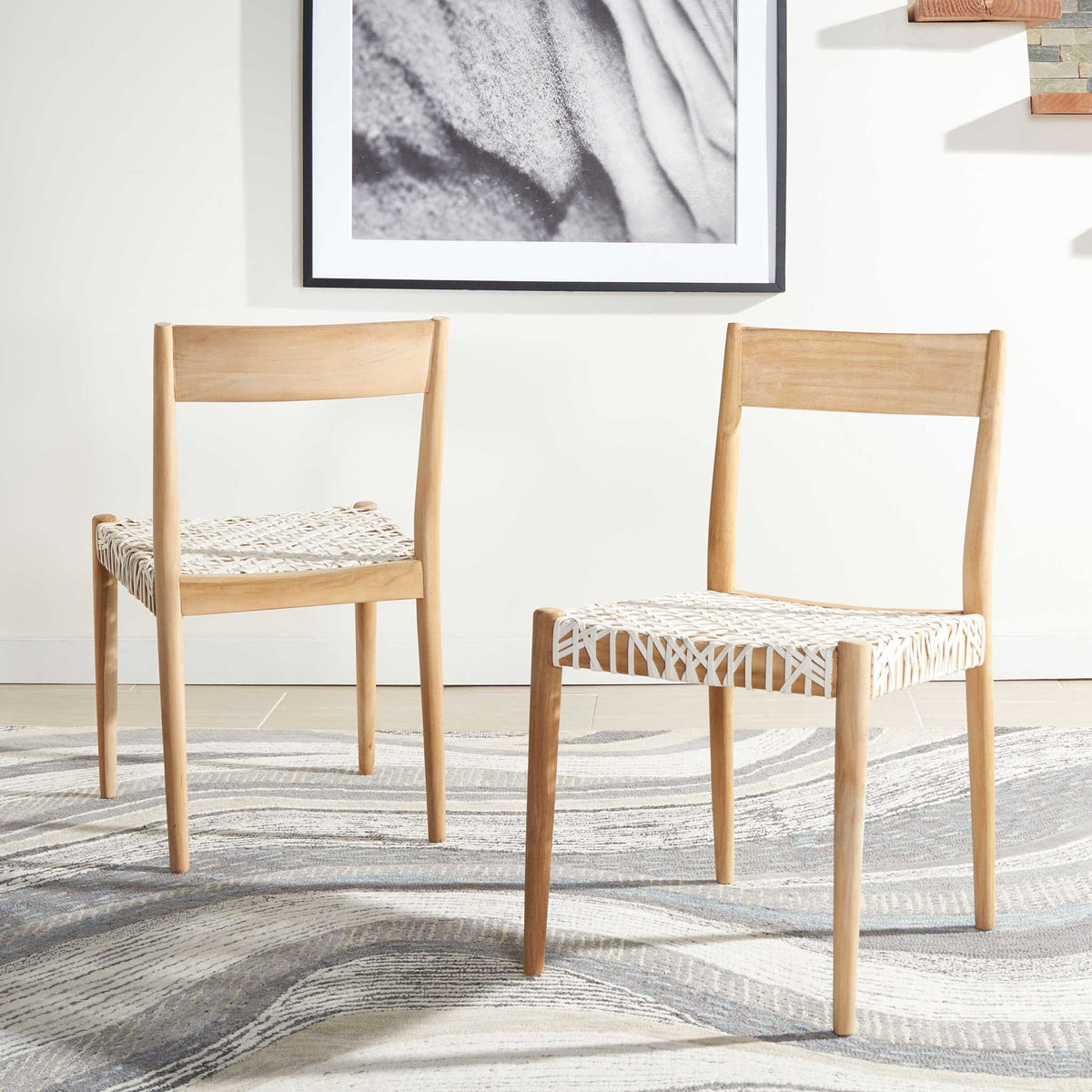 A pair of white leather dining chairs brightens the room with textured seats and natural wood