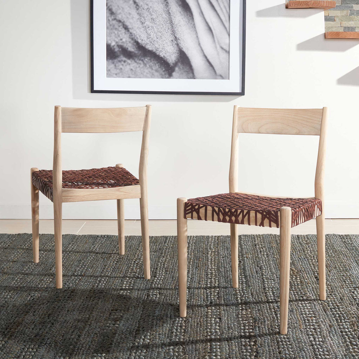 A matching pair of cognac leather dining chairs adds warmth and texture to a bright room