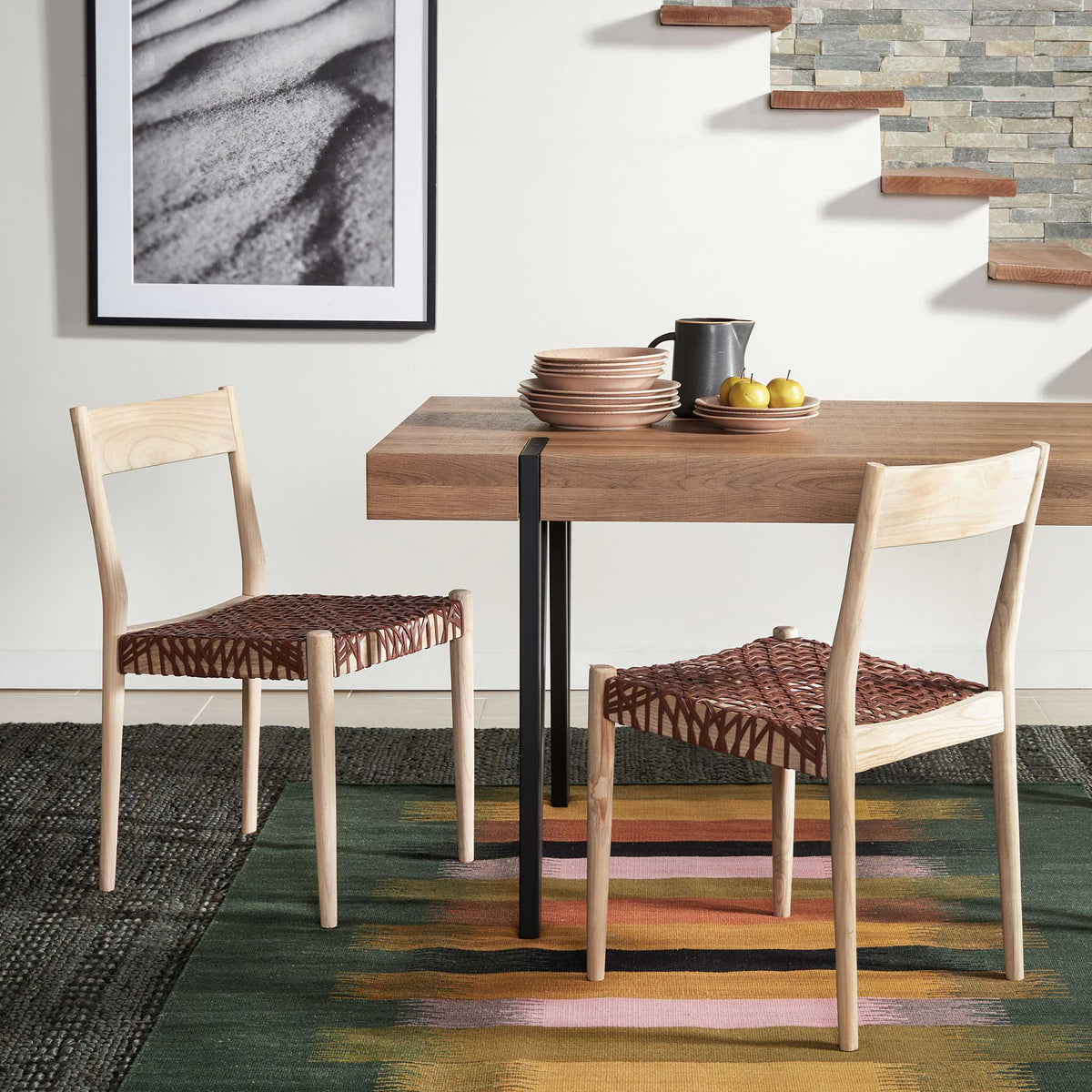 Woven cognac seats and natural wood frames bring inviting texture to the dining area