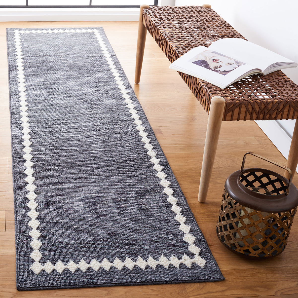 Gray and ivory bordered runner rug brings crisp contrast to warm wood floors in a minimalist space || ECR110F-28 || top_angle_room