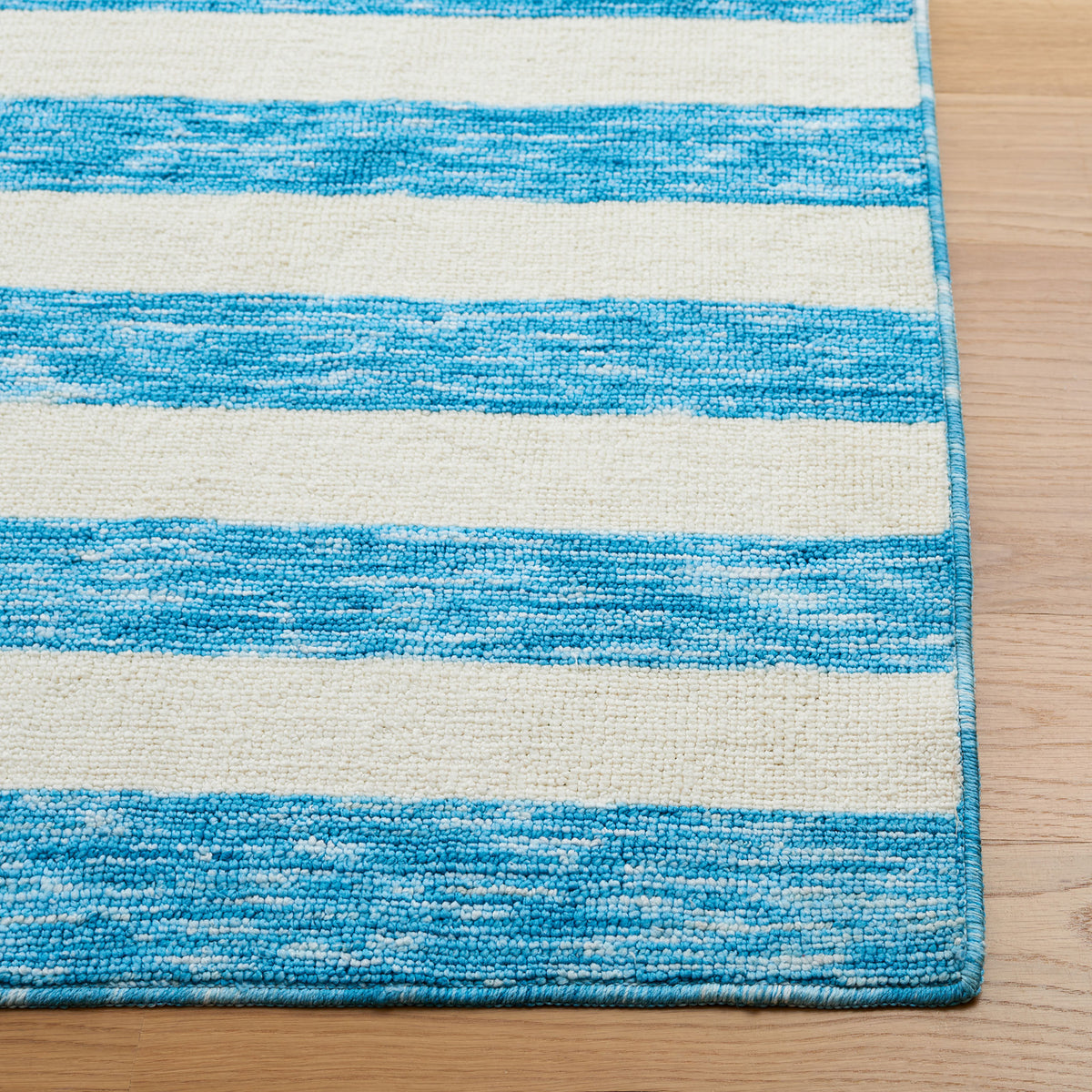 Heathered blue and ivory stripes with bound edges showcase the rug's looped texture || ECR115M-5 || corner_room