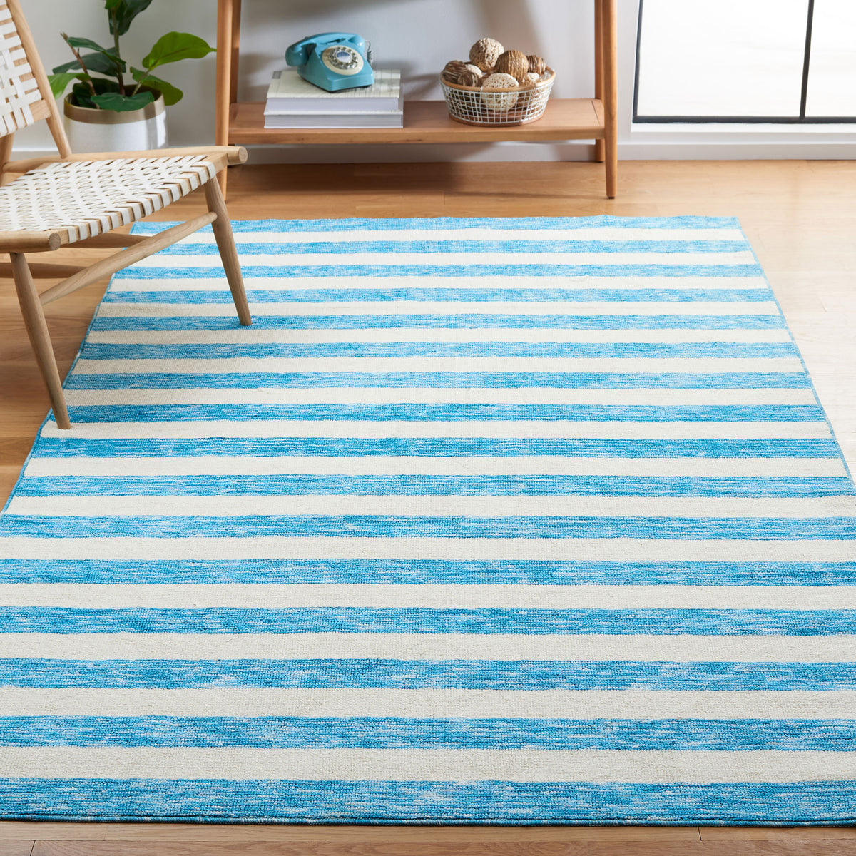 Striped blue and ivory rug anchors a light, airy living space with casual coastal charm || ECR115M-5 || front_angle_room