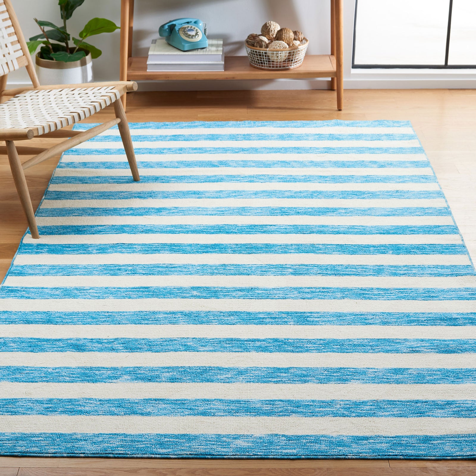 Striped blue and ivory rug anchors a light, airy living space with casual coastal charm || ECR115M-5 || front_angle_room