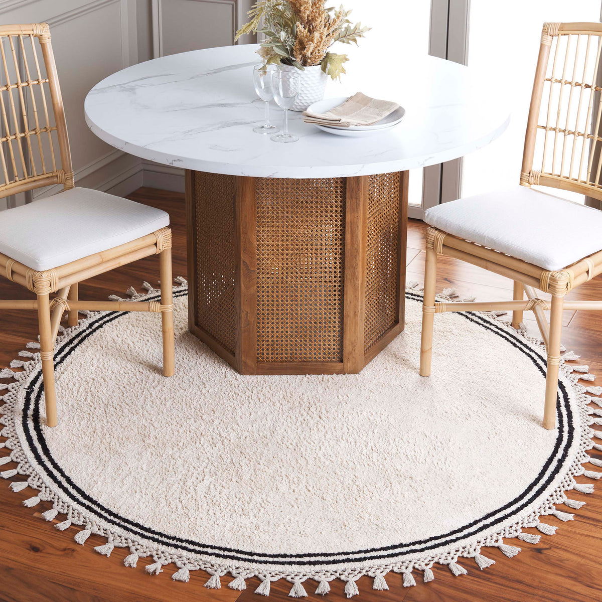 Round ivory rug frames the table with a slim double border and playful tassel fringe || ECR201A-5R || top_room