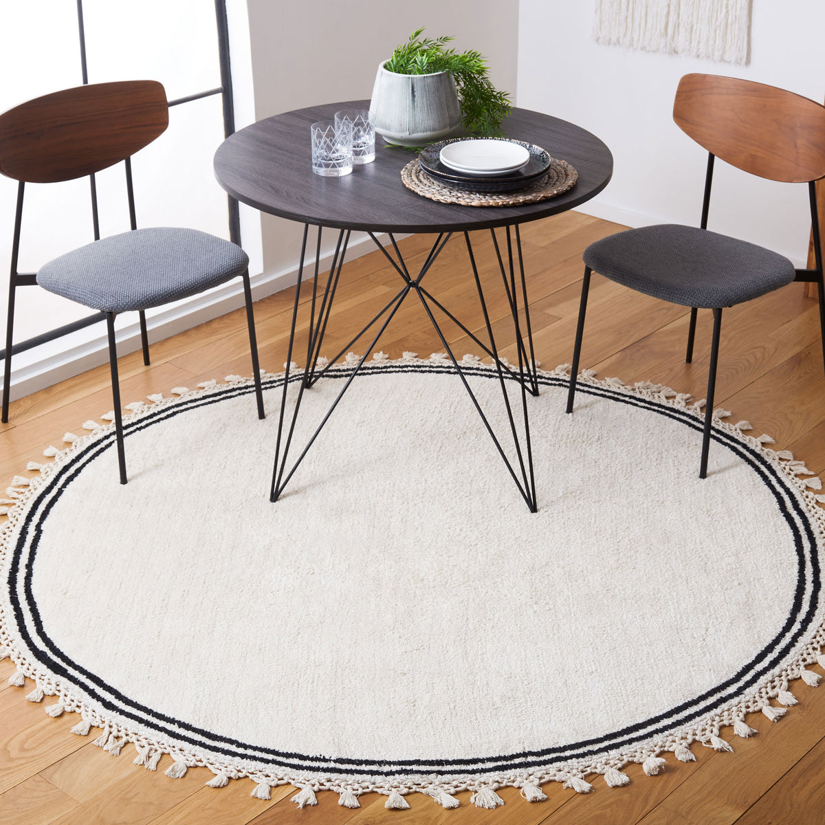 Soft ivory round rug with double black border and tassel fringe adds a refined boho touch || ECR201A-6R || top_room