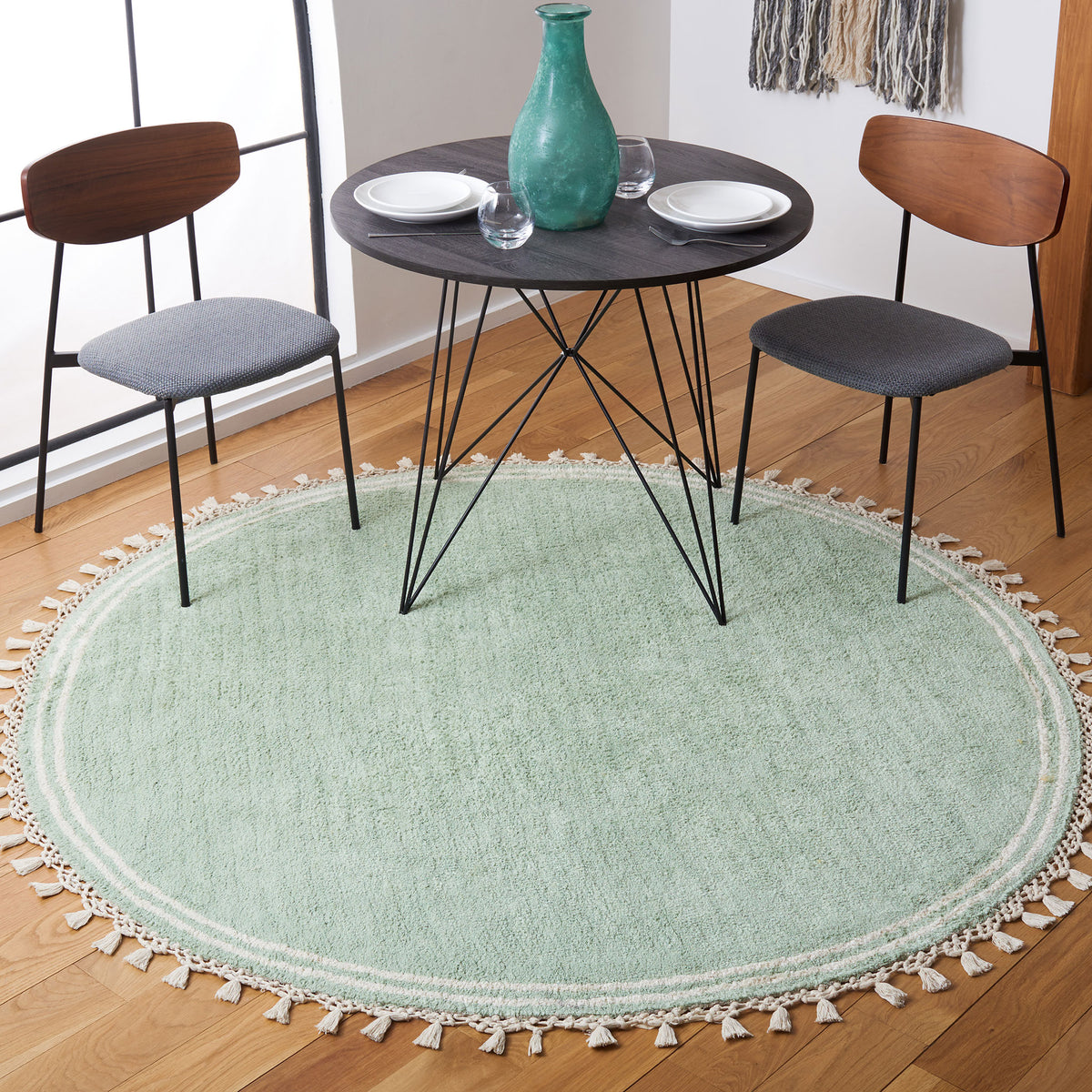Teal round rug anchors the dining set, with ivory border stripes and playful tassel fringe. || ECR201J-6R || top_angle_room