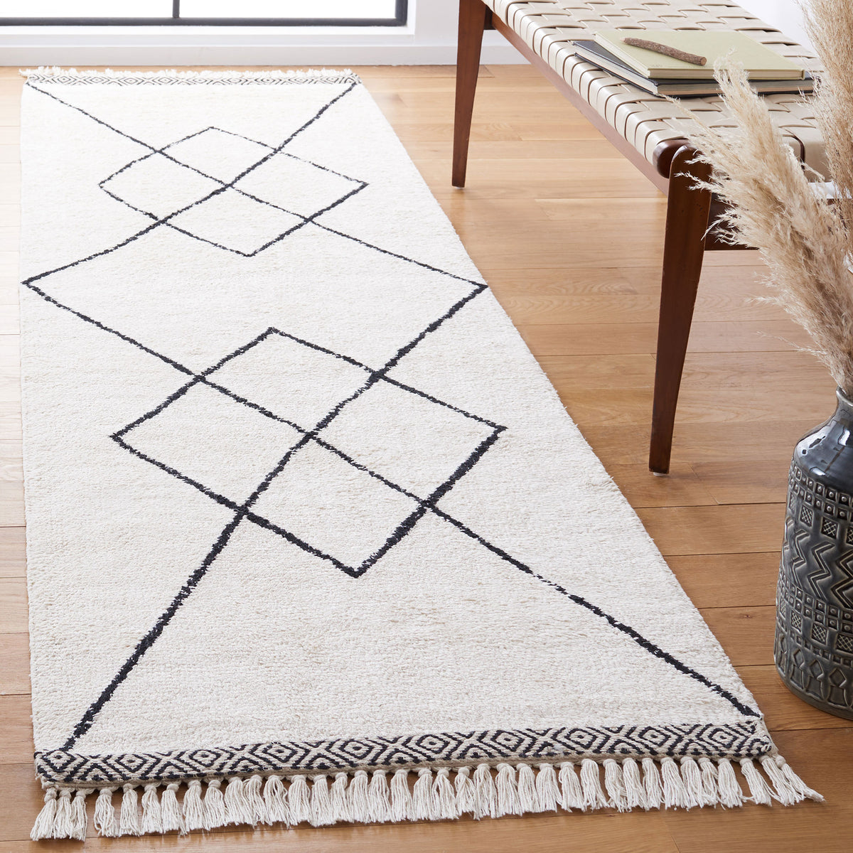 Ivory runner rug showcasing black diamond motifs, tassel fringe, and contrasting end borders || ECR210A-29 || front_angle_room