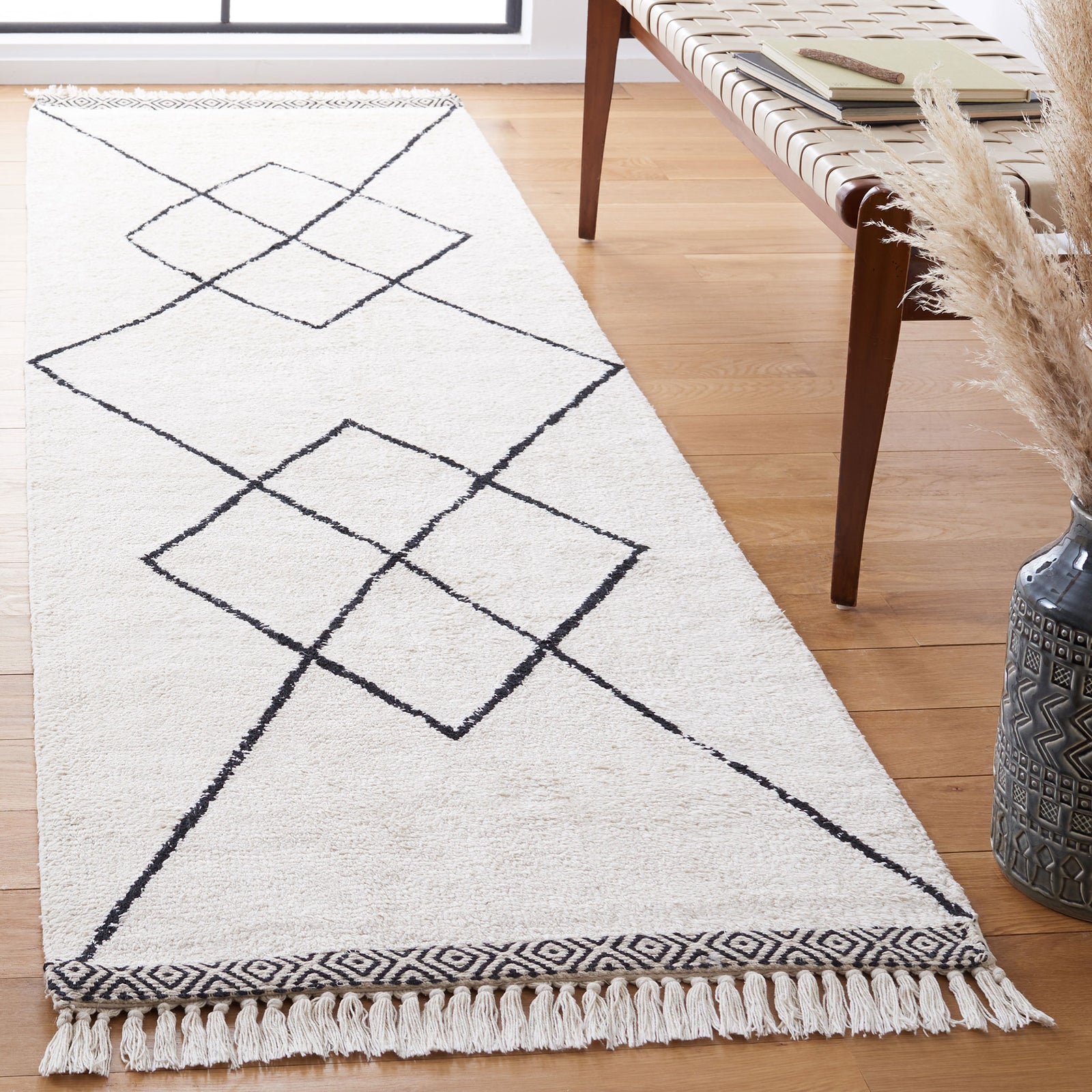Ivory runner rug showcasing black diamond motifs, tassel fringe, and contrasting end borders || ECR210A-29 || front_angle_room