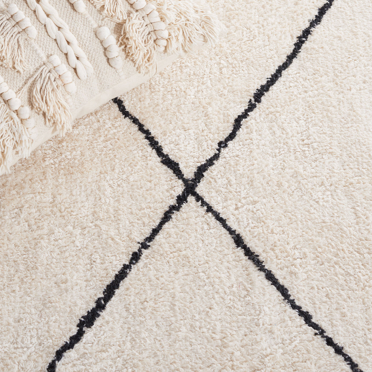 Soft ivory pile with intersecting black lines for a graphic, minimalist look || ECR210A-5 || detail_room