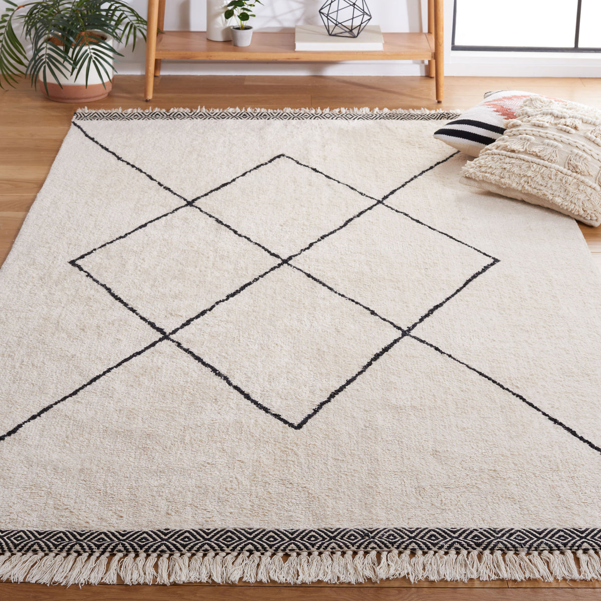 Ivory and black diamond rug adds modern warmth with tassel trim in a cozy living space || ECR210A-5 || front_angle_room