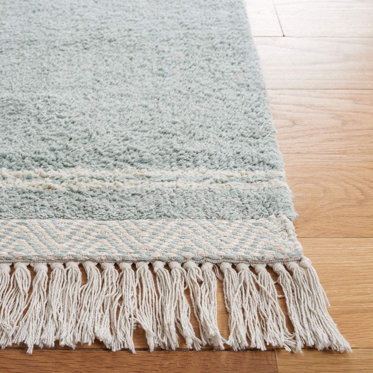 Tasseled edge and chevron border add crisp contrast to the soothing light blue rug || ECR211J-5 || corner_room