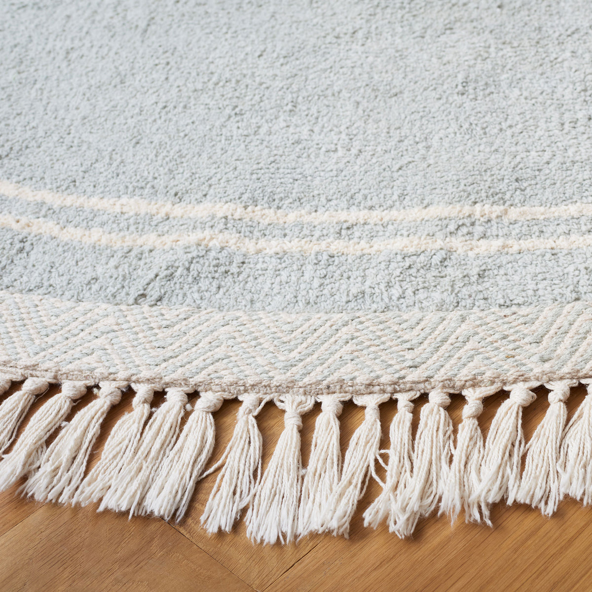 Textured light blue weave with ivory rings and knotted tassel fringe. || ECR211J-6R || detail_room