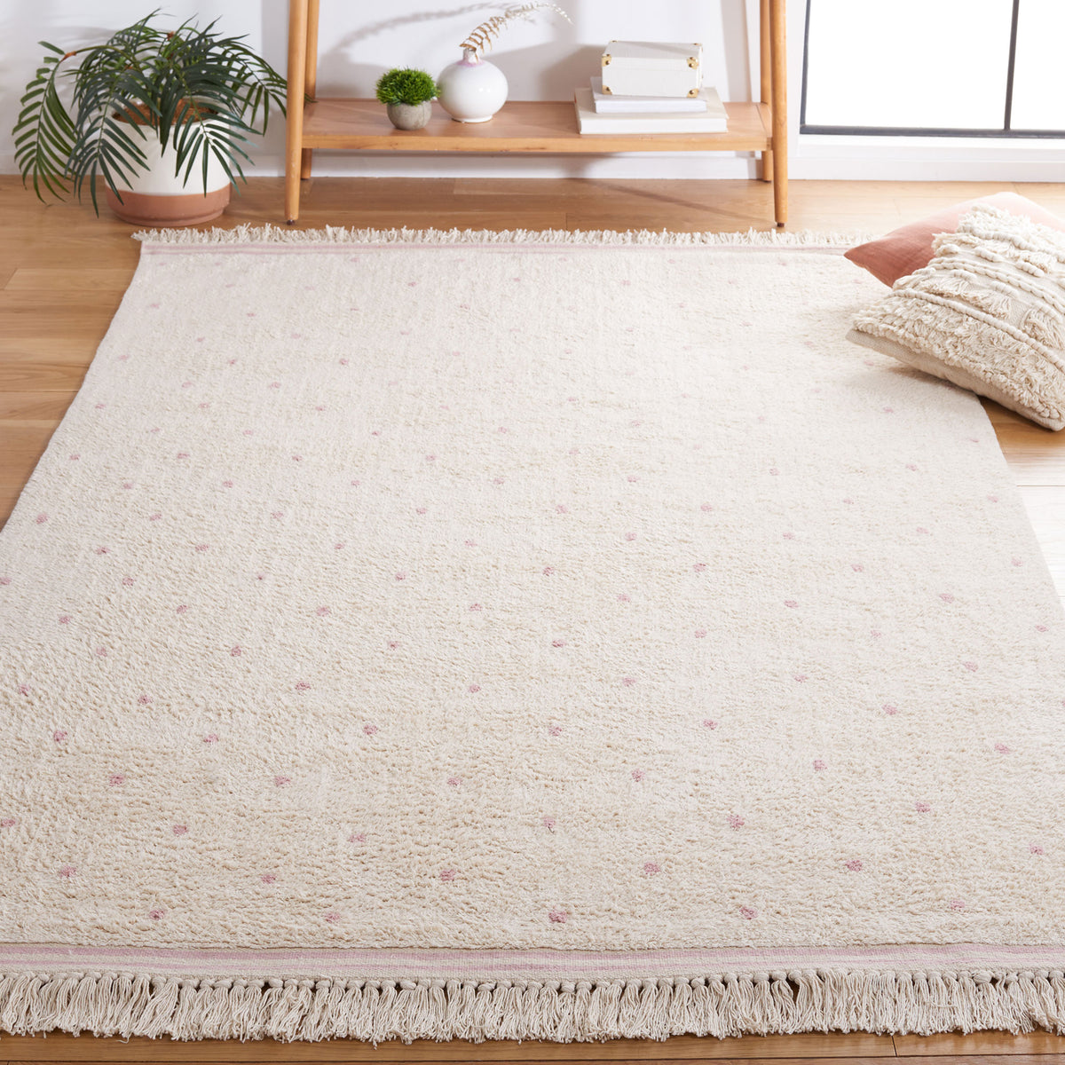 Ivory area rug with pink polka dots and tasseled border adds cozy charm to living spaces || ECR212U-5 || top_angle_room