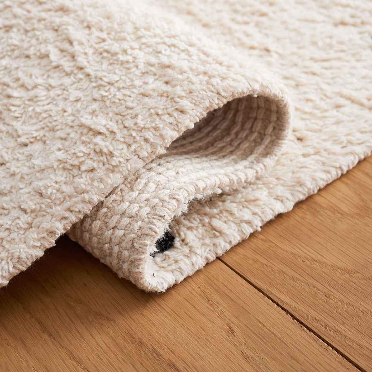Flexible, medium-pile rug folds easily, revealing soft texture and durable underside. || ECR212Z-5 || fold_room