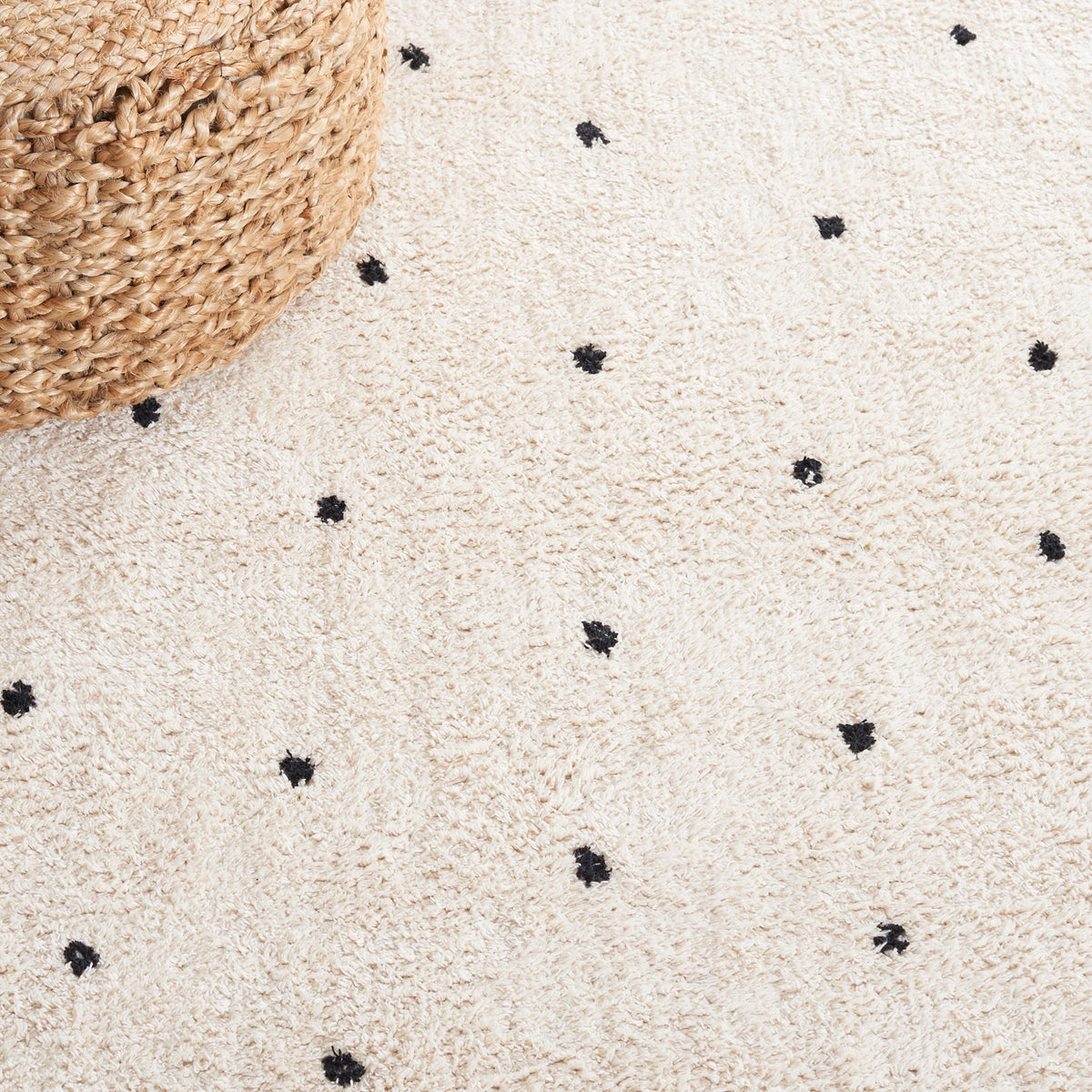 Close-up of tufted dots on soft ivory pile for a subtle, playful pattern. || ECR212Z-5 || detail_room