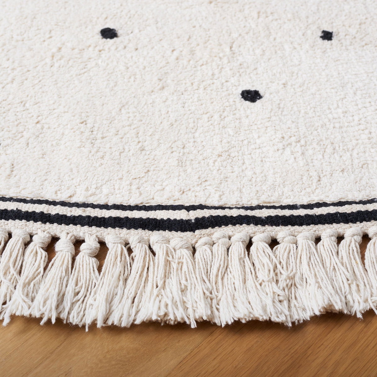Soft, textured pile with black dot motif and tassel fringe along the border || ECR212Z-6R || detail_room