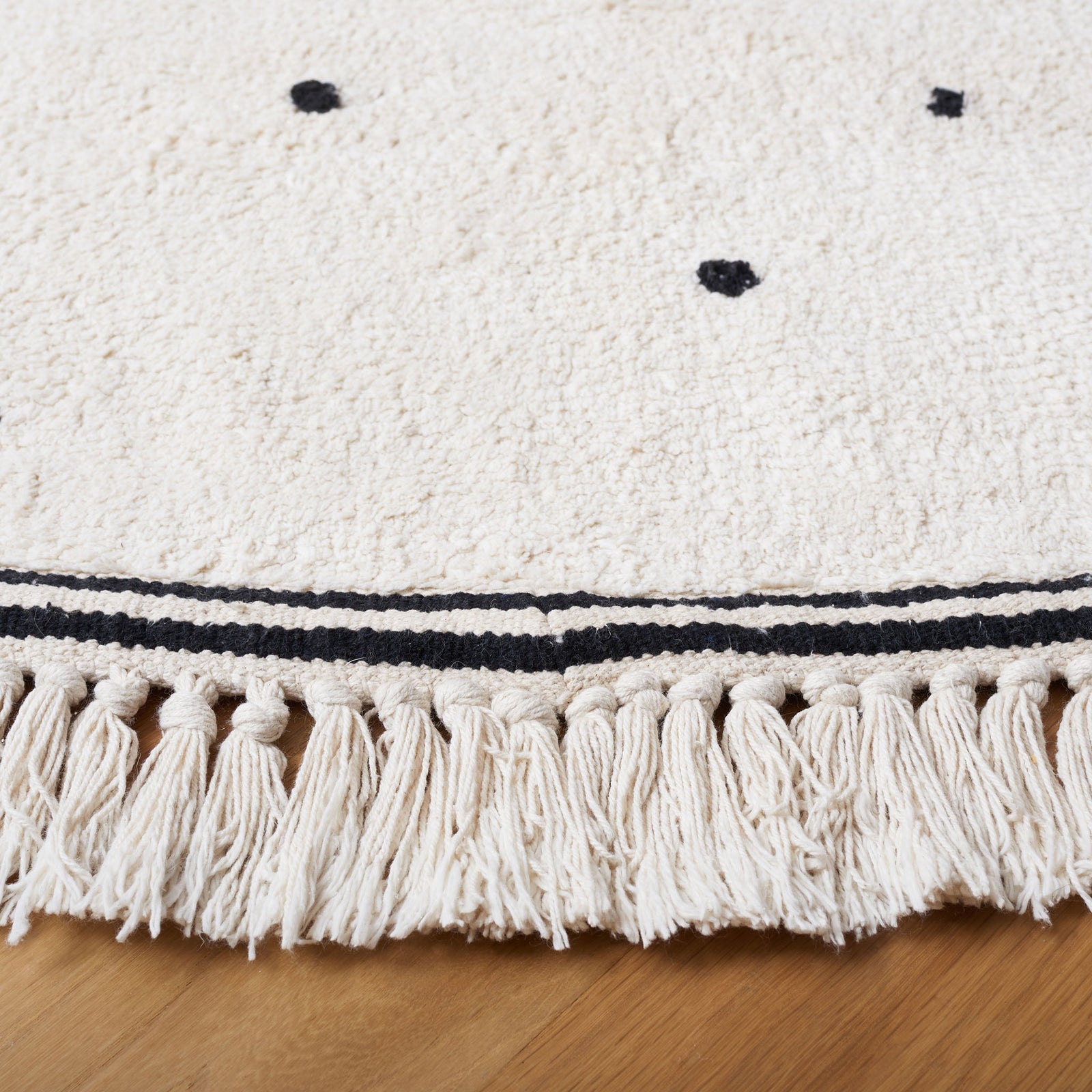 Soft, textured pile with black dot motif and tassel fringe along the border || ECR212Z-6R || detail_room