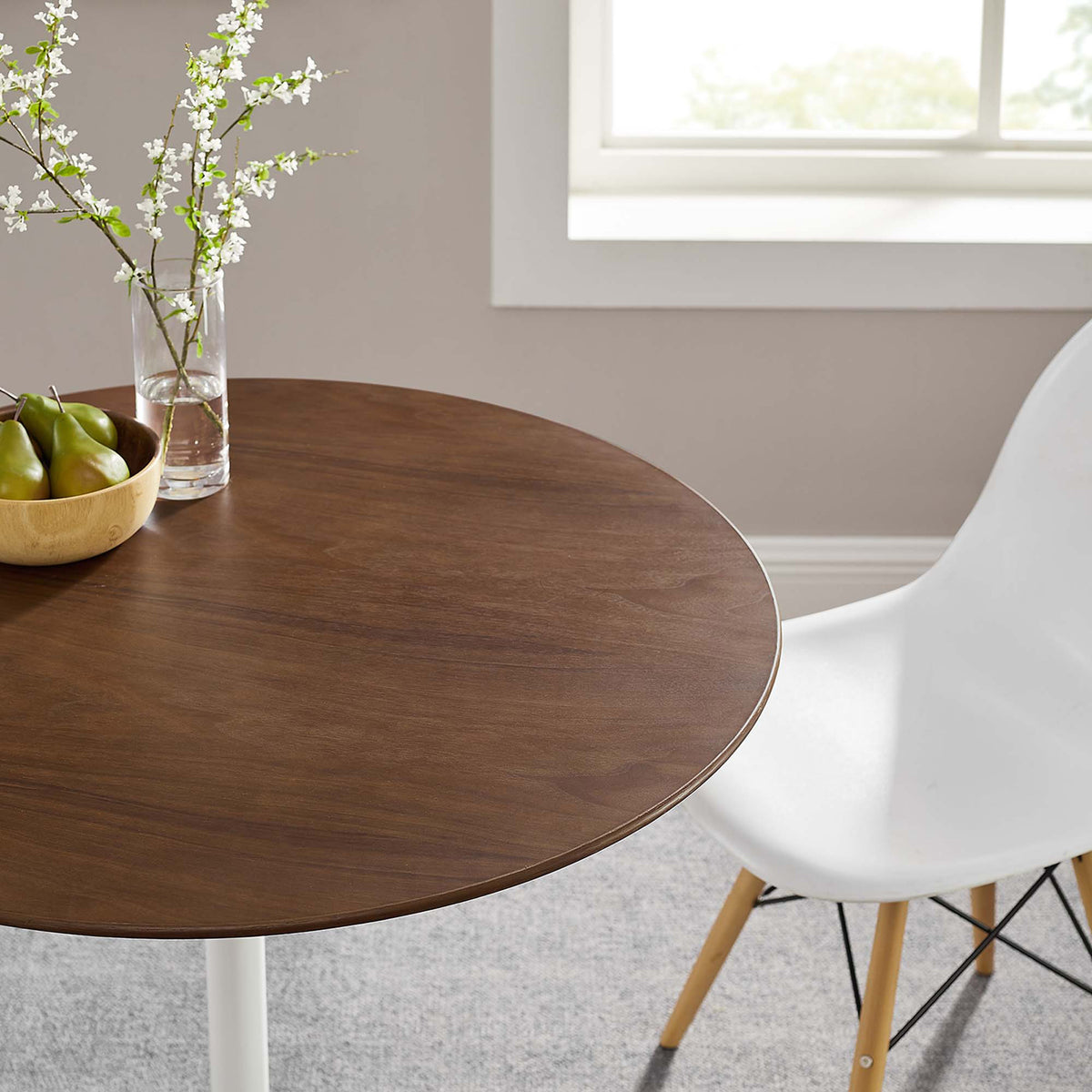 Smooth brown walnut grain and a slim beveled edge give the round tabletop inviting warmth.