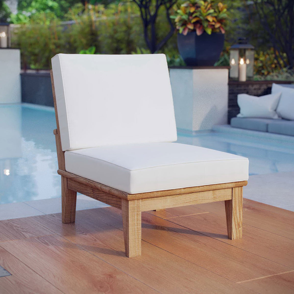 Marina armless teak chair with white cushions positioned beside a tranquil pool || EEI-1150-NAT-WHI-SET || front_angle_room