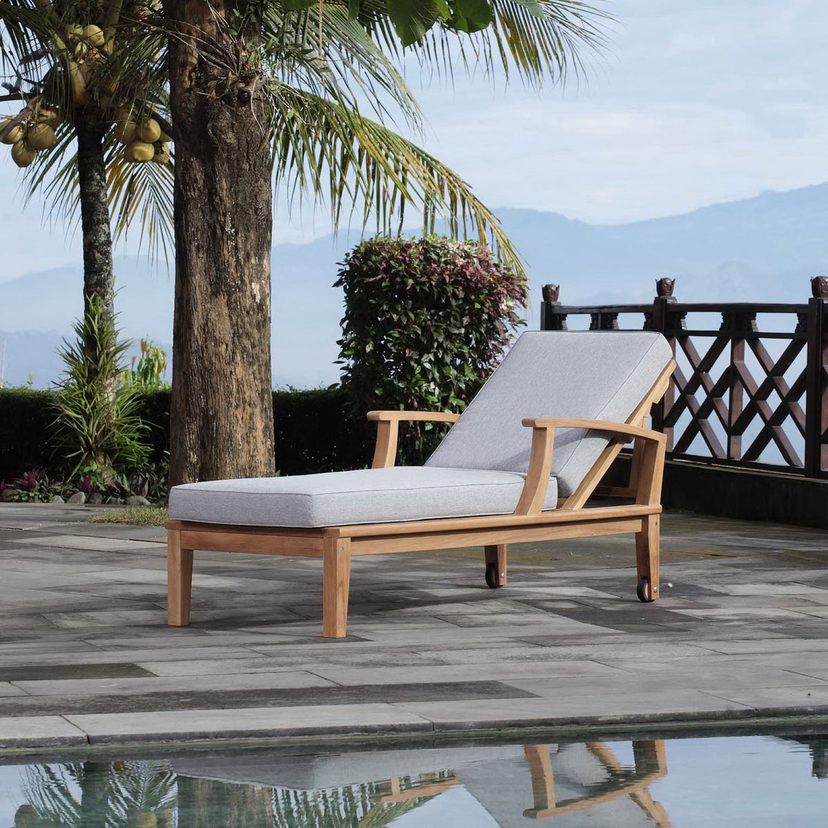 Teak chaise lounge with gray cushions styled by a poolside patio for relaxed outdoor lounging || EEI-1151-NAT-GRY-SET || front_angle_room
