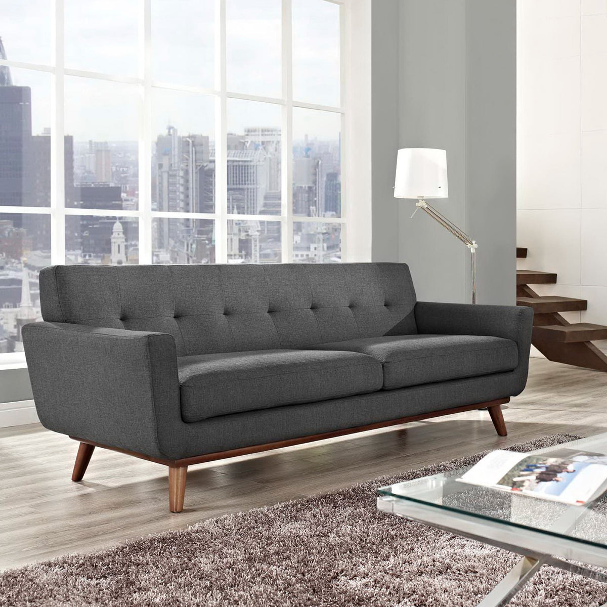 Dark gray sofa brings deep cushioned seating and a warm wood base to the living room