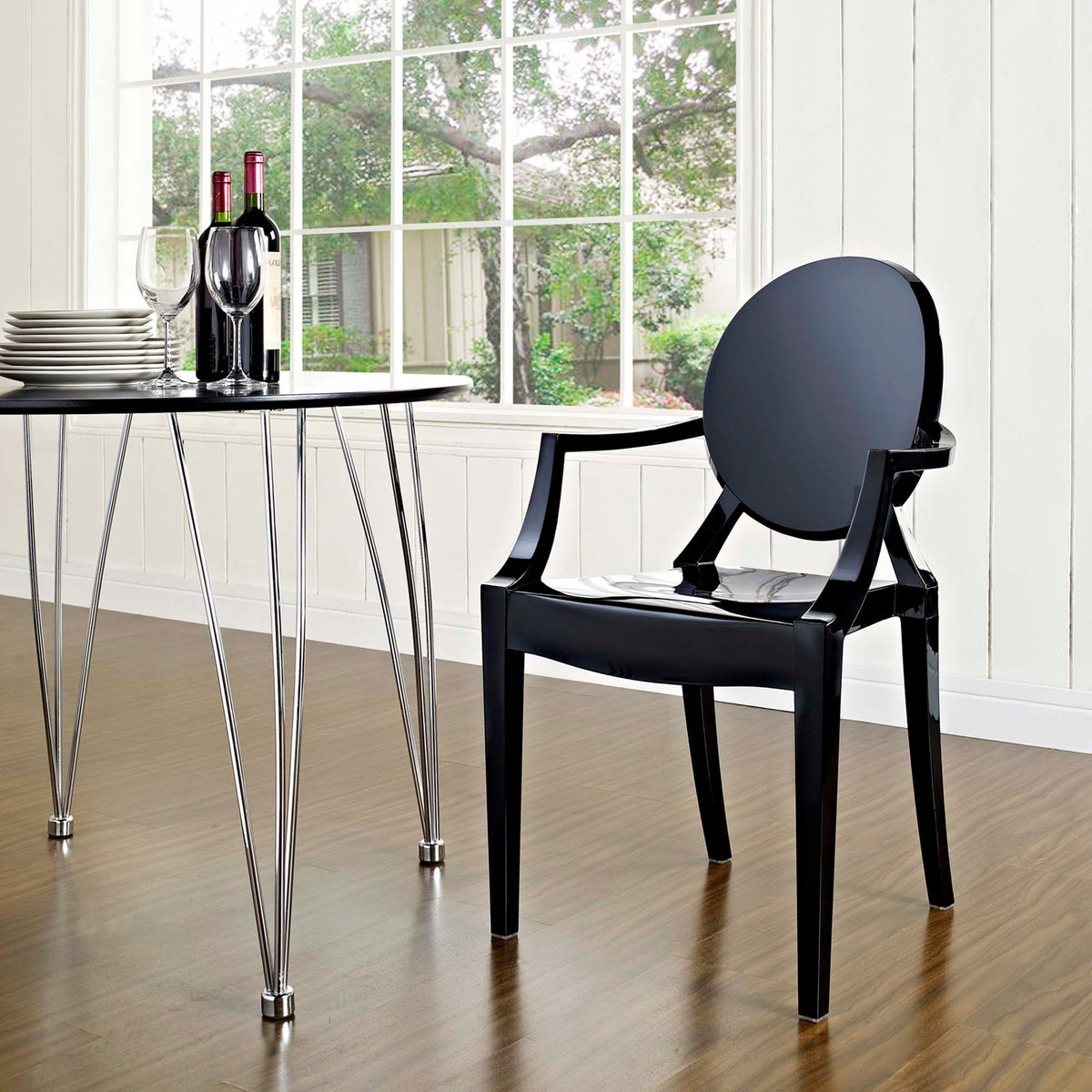 Glossy black seat and tapered legs complement an airy dining area and streamlined table