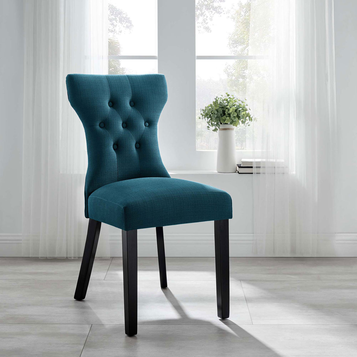 Azure upholstered dining chair bringing sophisticated comfort to a bright contemporary room || EEI-1380-AZU || front_angle_room