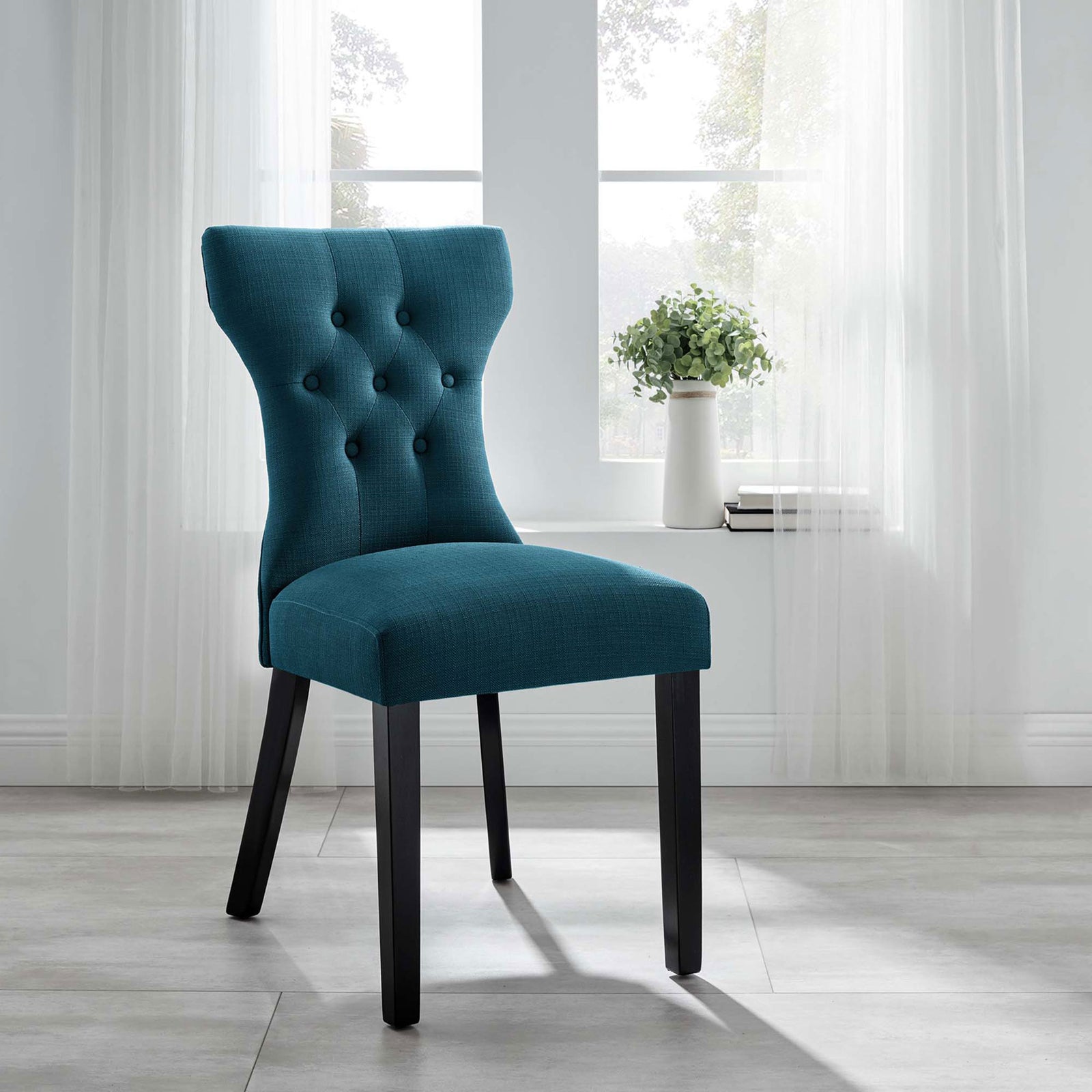 Azure upholstered dining chair bringing sophisticated comfort to a bright contemporary room || EEI-1380-AZU || front_angle_room