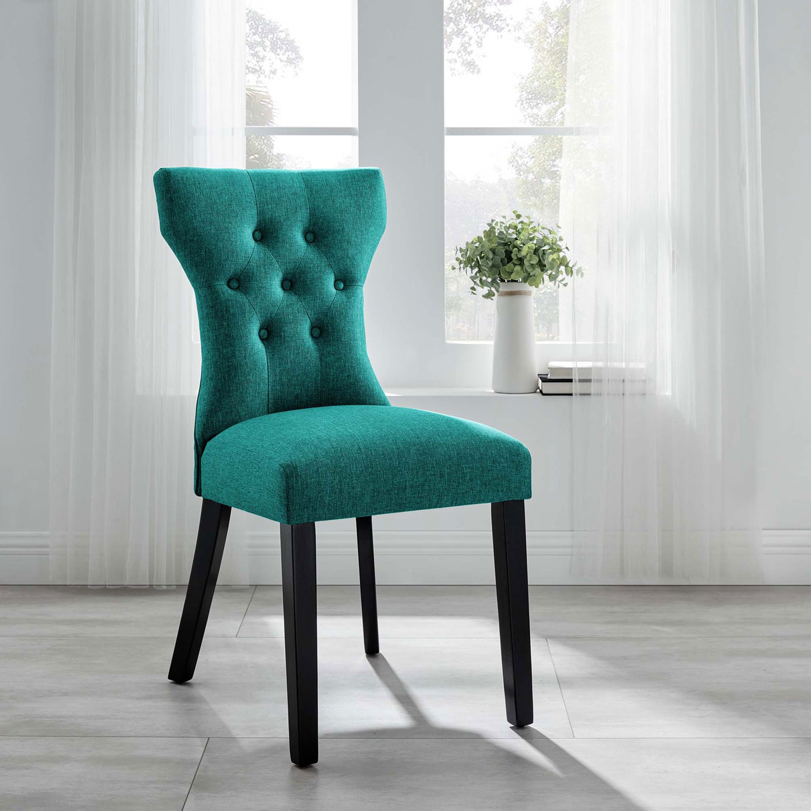 Teal tufted dining chair adding a pop of color and sculpted style to a bright modern dining space || EEI-1380-TEA || front_angle_room