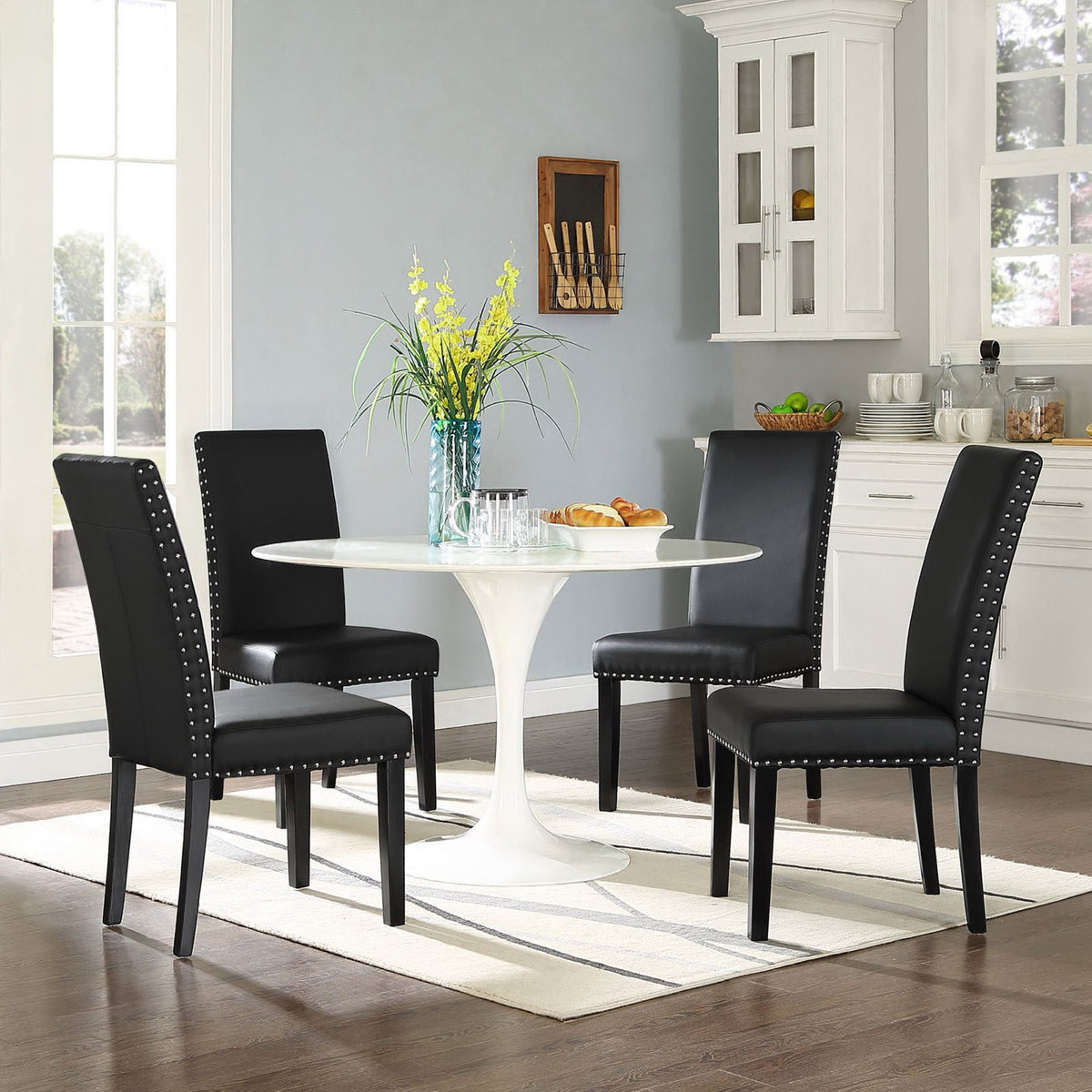Set of black faux leather dining chairs surrounding a round white table in a cozy breakfast nook || EEI-1491-BLK || front_angle_room