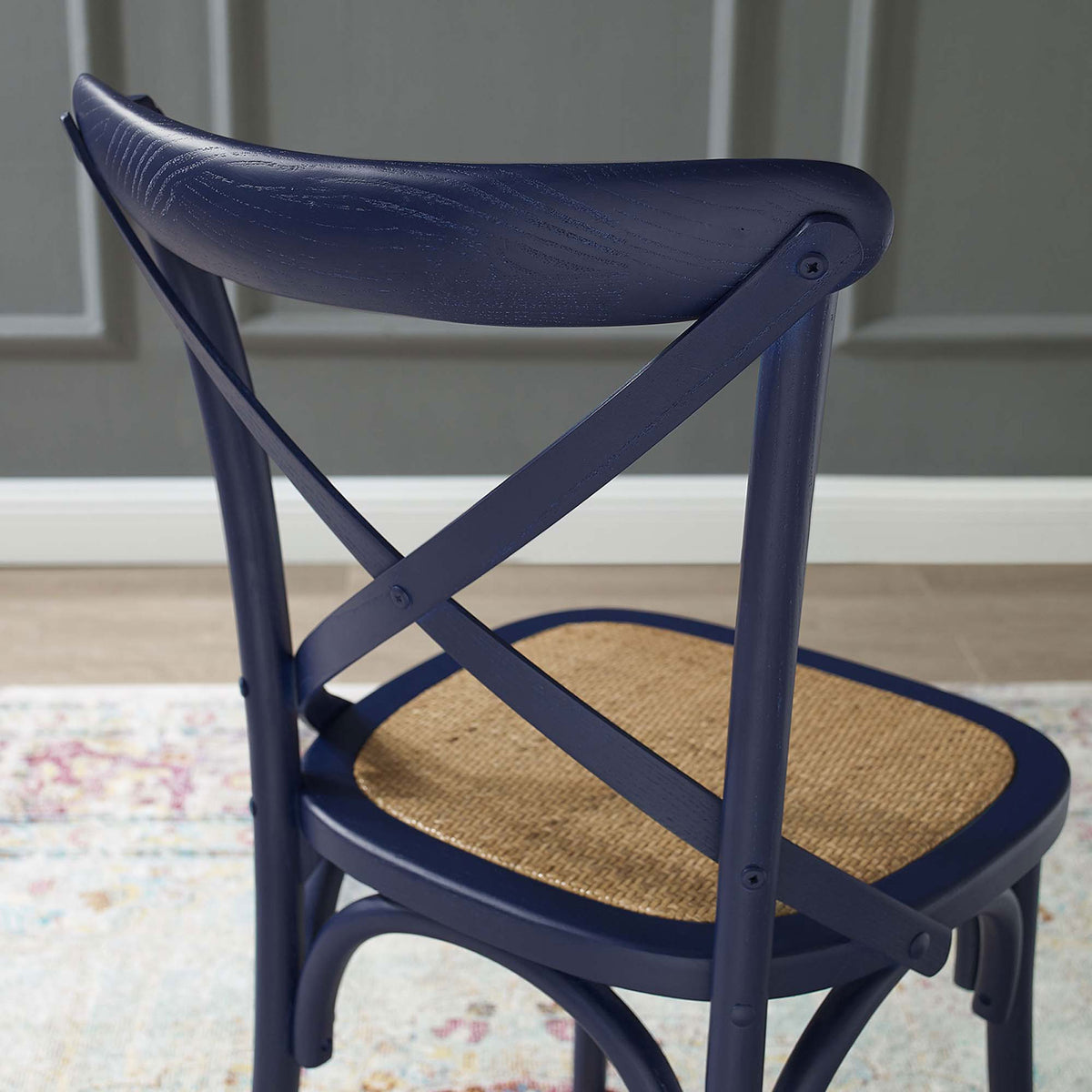 Midnight blue cross back chair with rattan seat styled against paneled gray wall. || EEI-1541-MID || detail_room