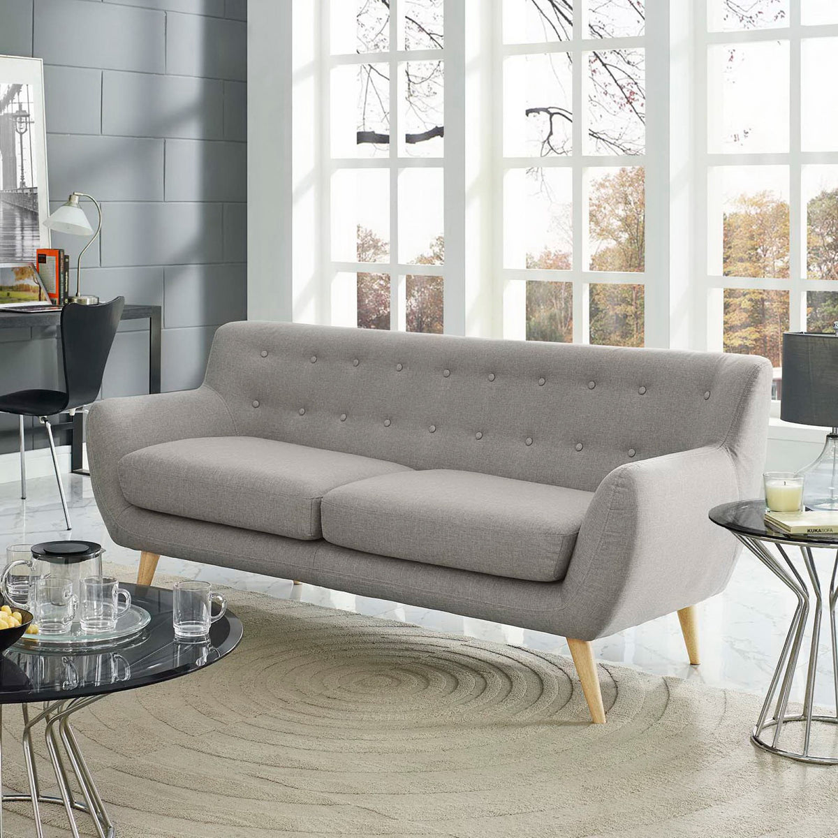Light gray two-seat sofa adds plush comfort with a tufted back and rounded armrests