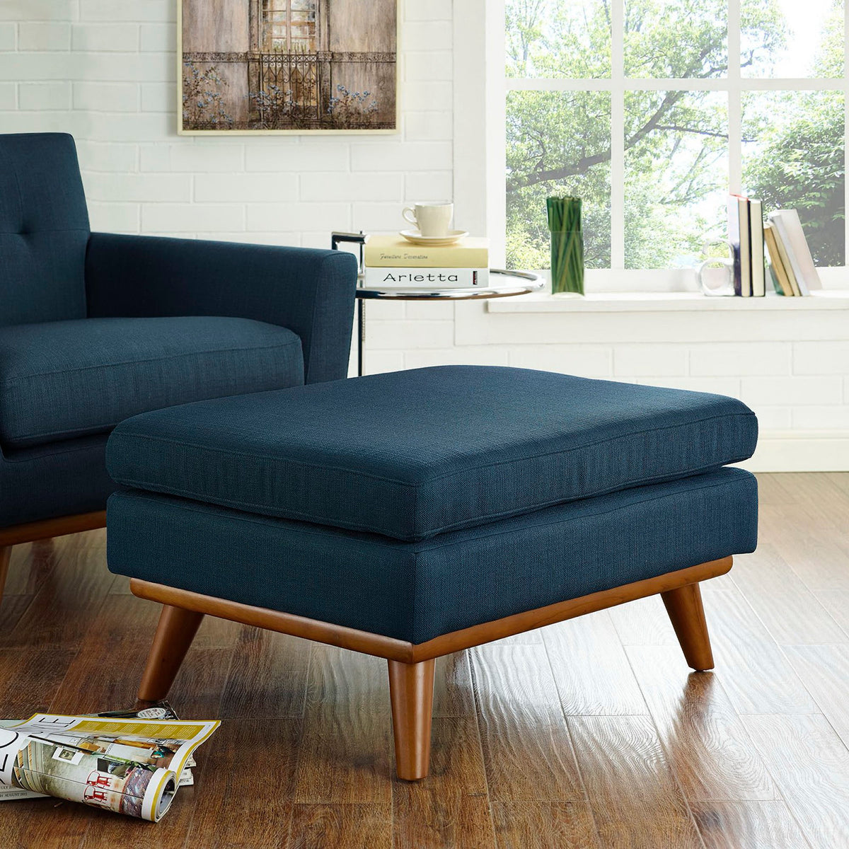 Plush blue ottoman brings inviting comfort and warm wood accents to a seating area