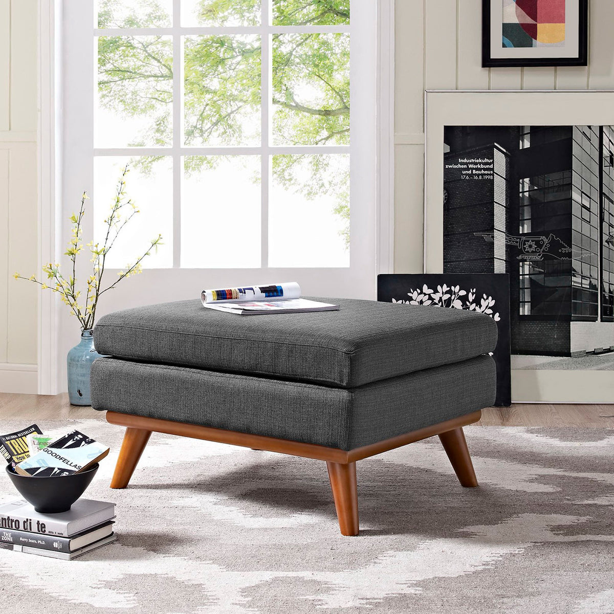 Charcoal gray ottoman with wood accents adds a cozy resting spot to the living room