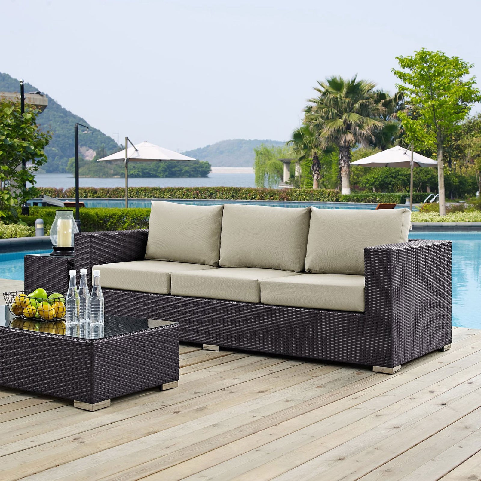 Convene espresso and beige patio sofa placed by the pool for relaxed outdoor lounging and entertaining. || EEI-1844-EXP-BEI || front_angle_room