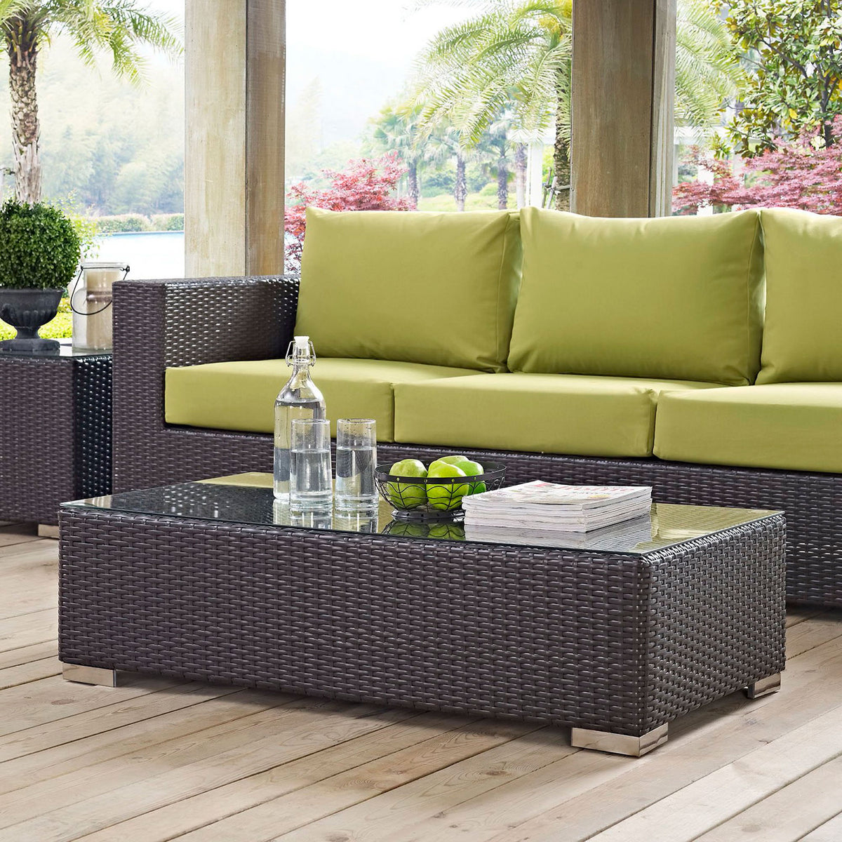 Espresso wicker outdoor coffee table styled with sofa, greenery, and lake view on covered deck || EEI-1908-EXP || front_angle_room