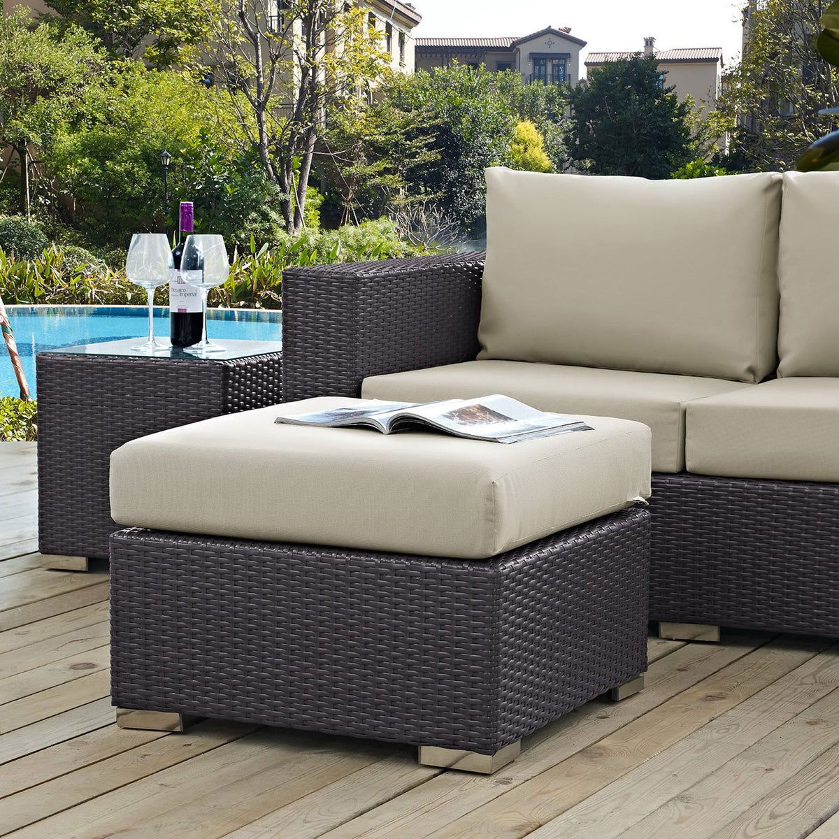 Beige cushioned ottoman pairs with espresso sectional to create a stylish poolside lounge area || EEI-1911-EXP-BEI || front_angle_room