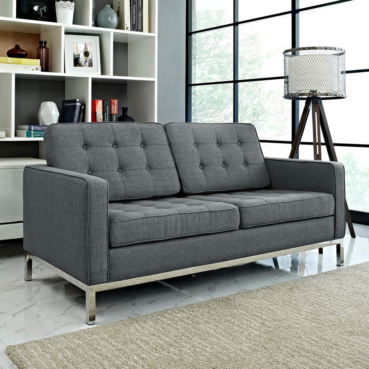 Button-tufted gray cushions and roomy seating offer comfort with a polished silver base.