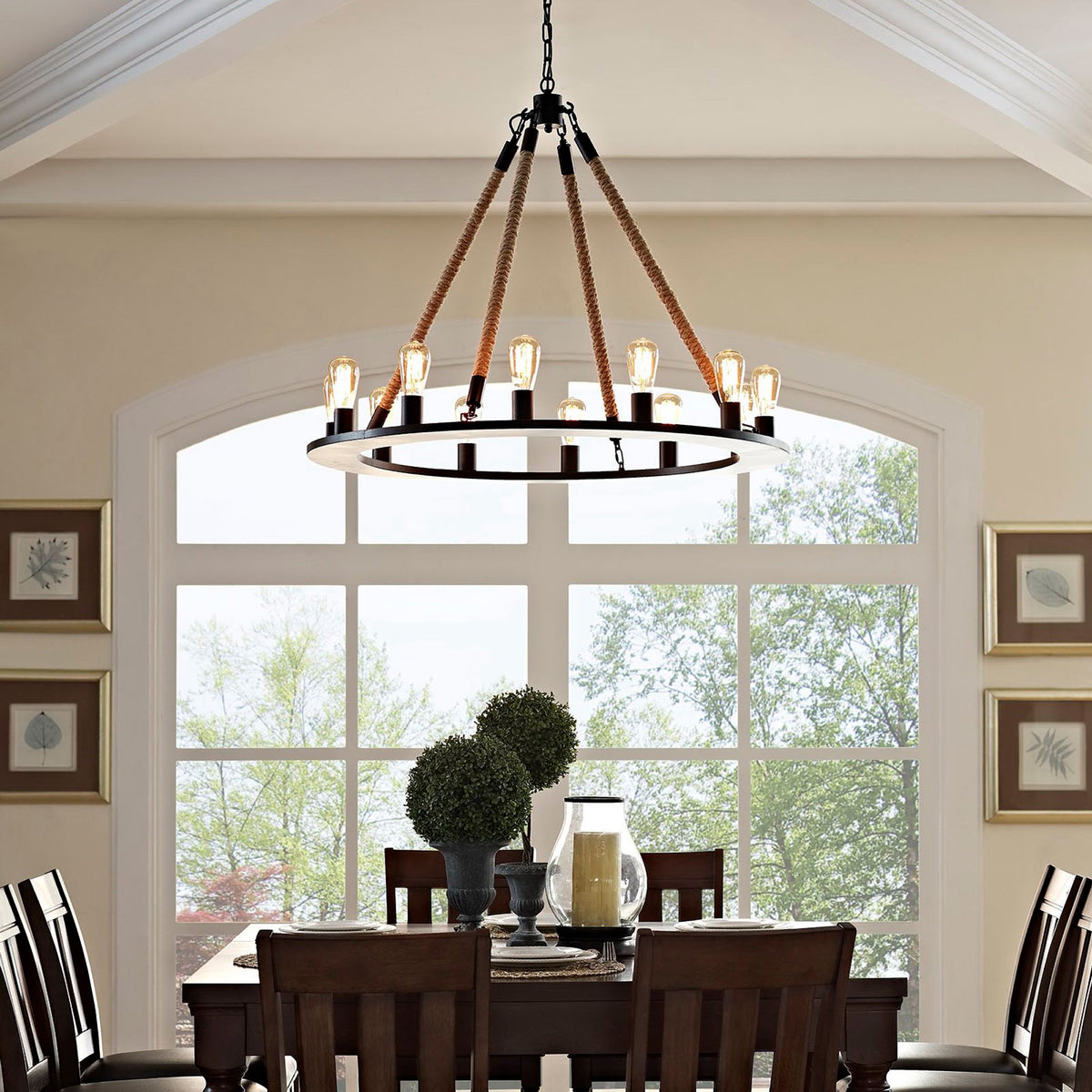 A wide ring of glowing bulbs hangs from rustic rope supports above a dining area