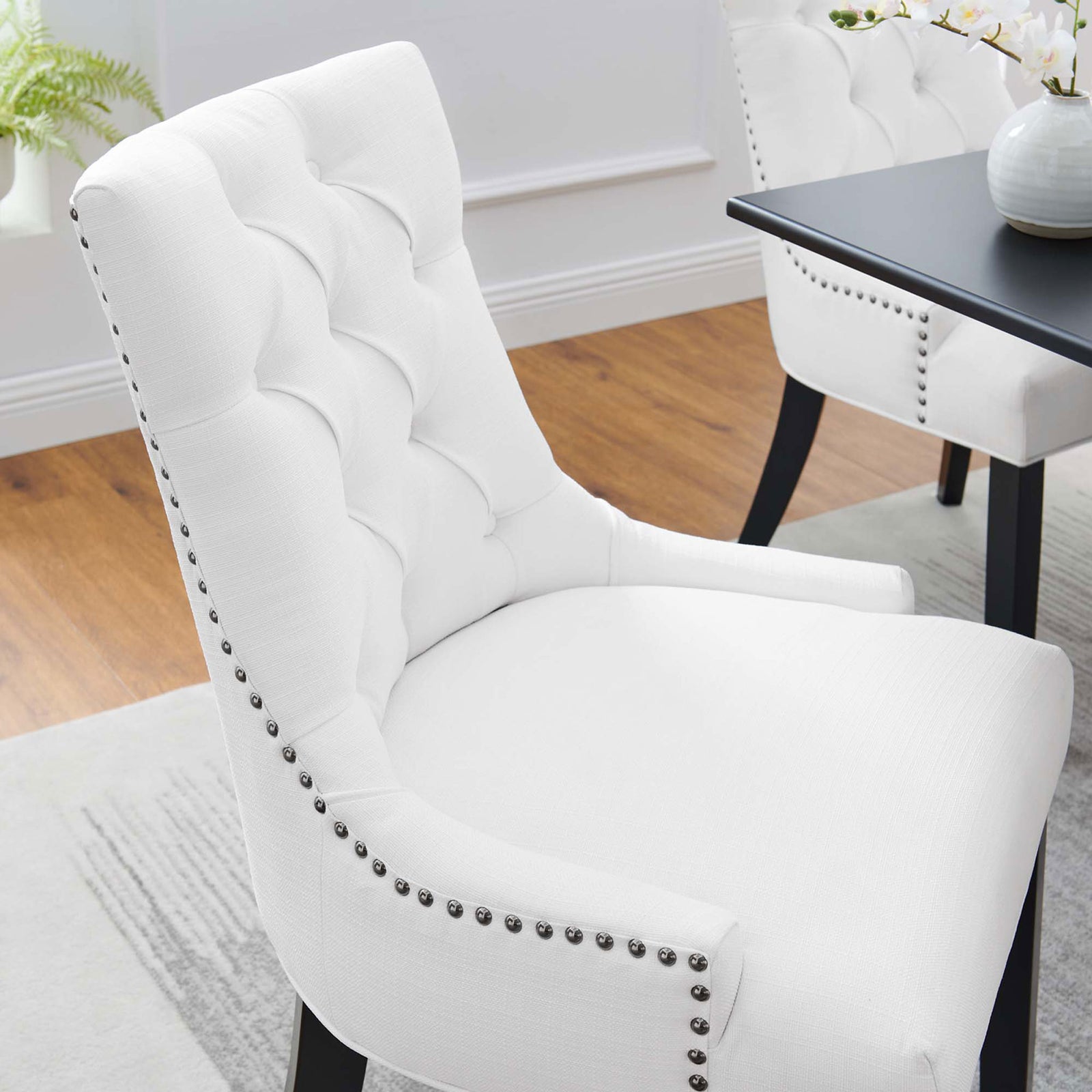 Tufted white dining chair in a bright dining room with curved back and nailhead accents || EEI-2223-WHI || detail_room