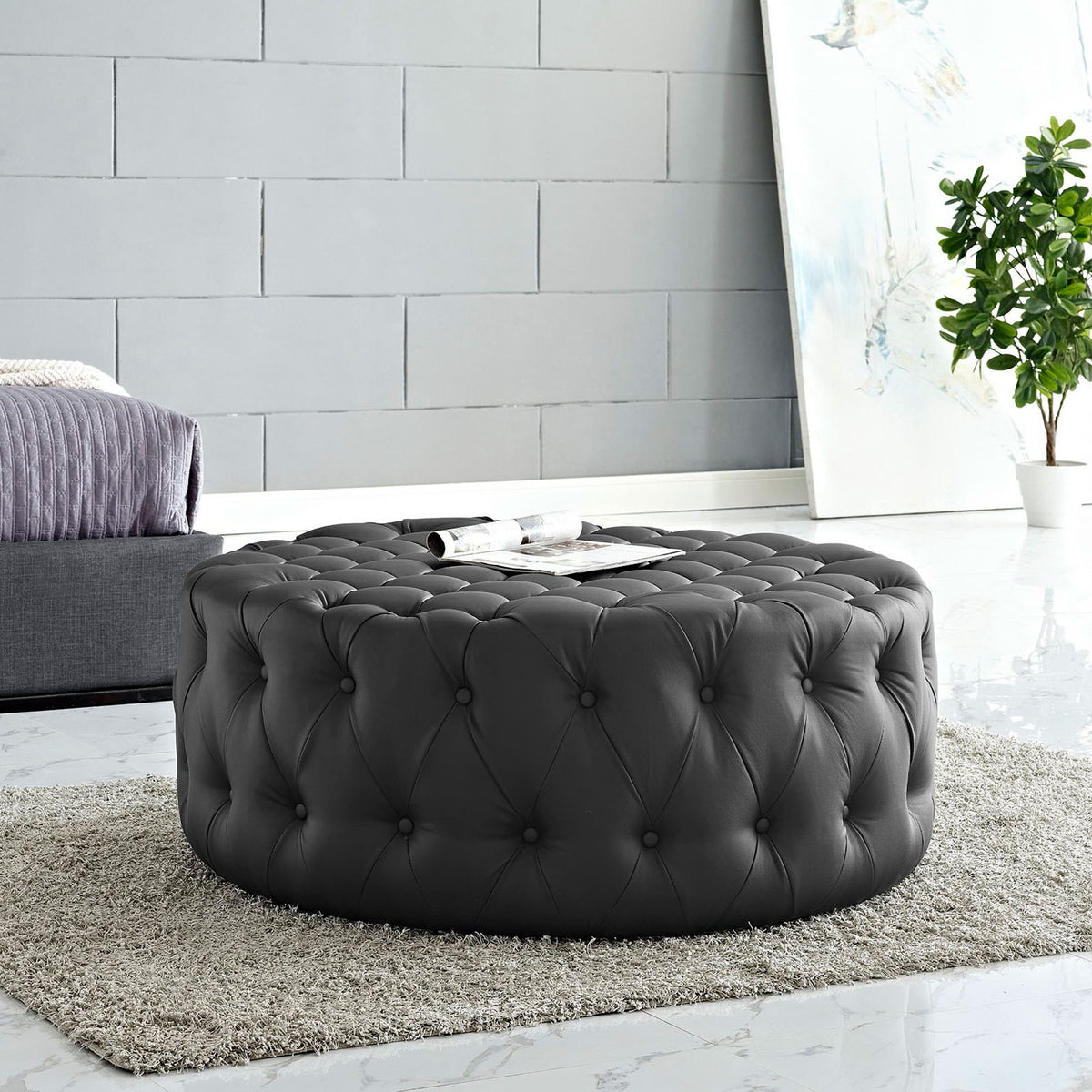 Tufted black round ottoman softens a modern bedroom sitting area with plush texture and versatile function || EEI-2224-BLK || front_angle_room