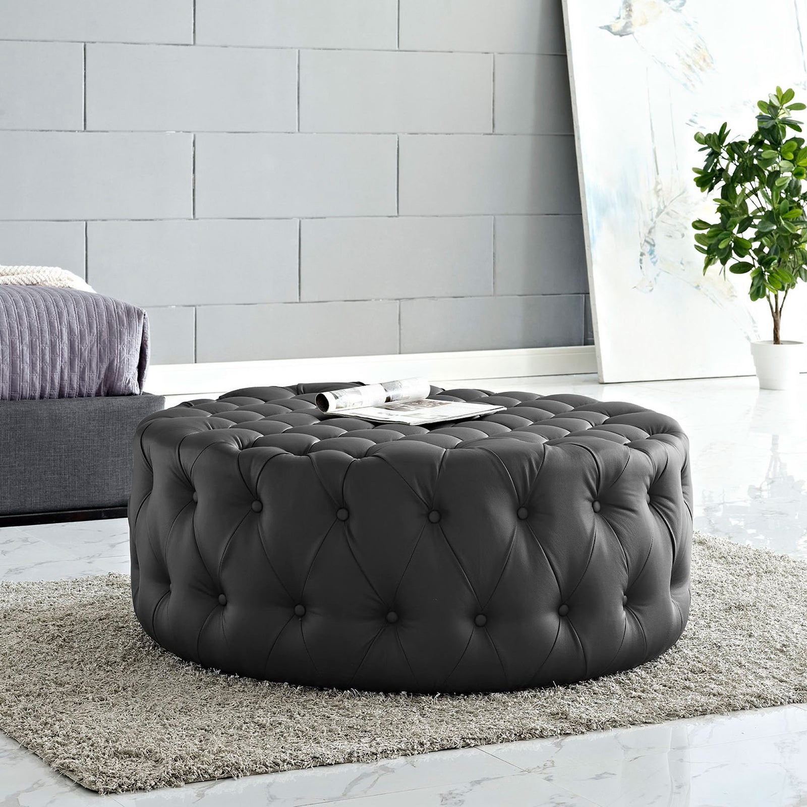 Tufted black round ottoman softens a modern bedroom sitting area with plush texture and versatile function || EEI-2224-BLK || front_angle_room