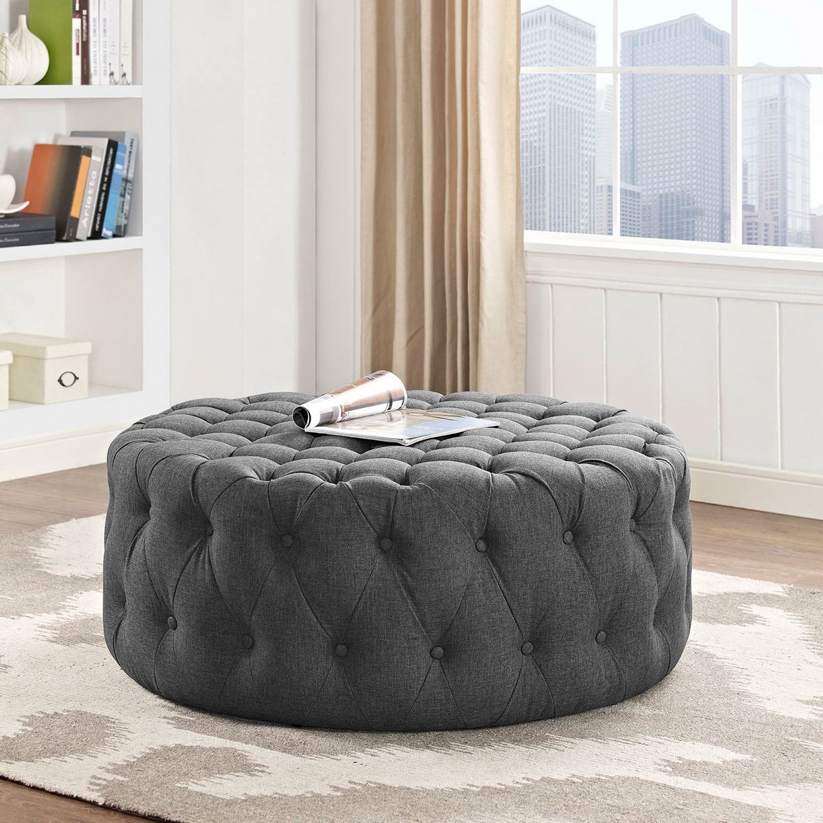 Gray tufted ottoman styled in a bright living room, perfect as a coffee table centerpiece || EEI-2225-GRY || front_angle_room