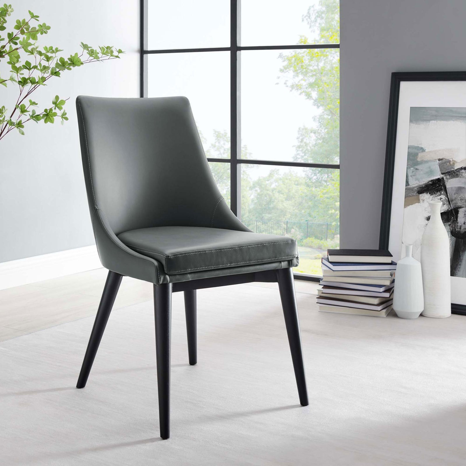 Gray vegan leather dining chair with black legs styled in a bright dining nook with art and decor || EEI-2226-GRY || front_angle_room