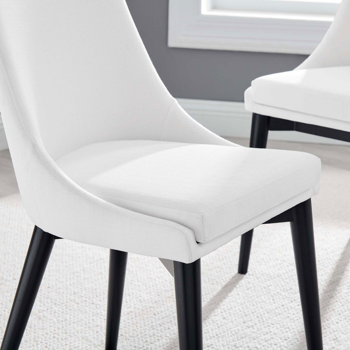 White upholstered dining chair styled in a modern gray dining room with soft textured flooring || EEI-2227-WHI || detail_room