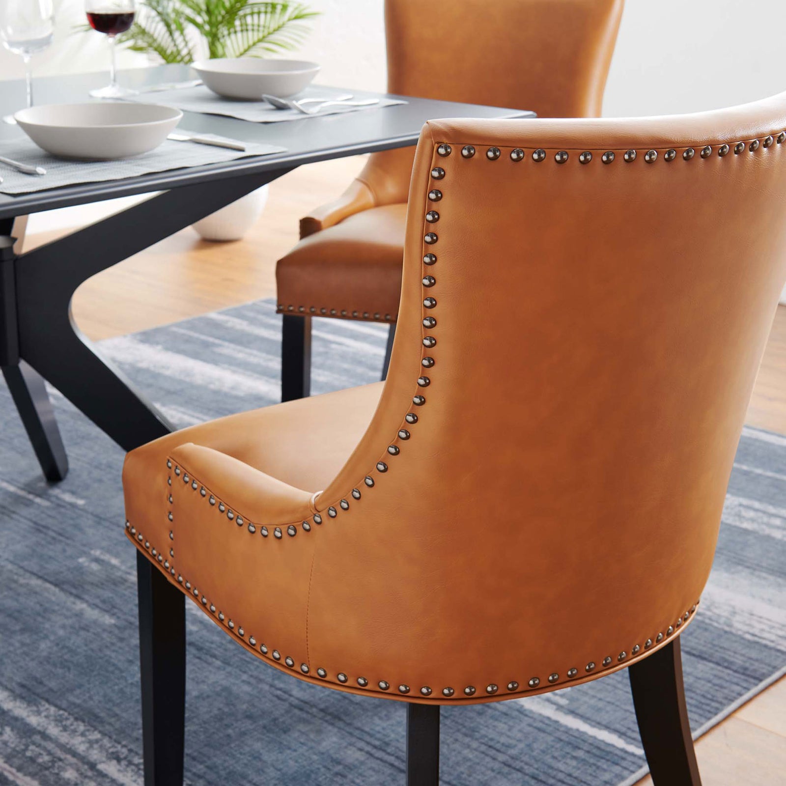 Tan vegan leather dining chairs styled around a modern dining table on a blue rug || EEI-2228-TAN || detail_room