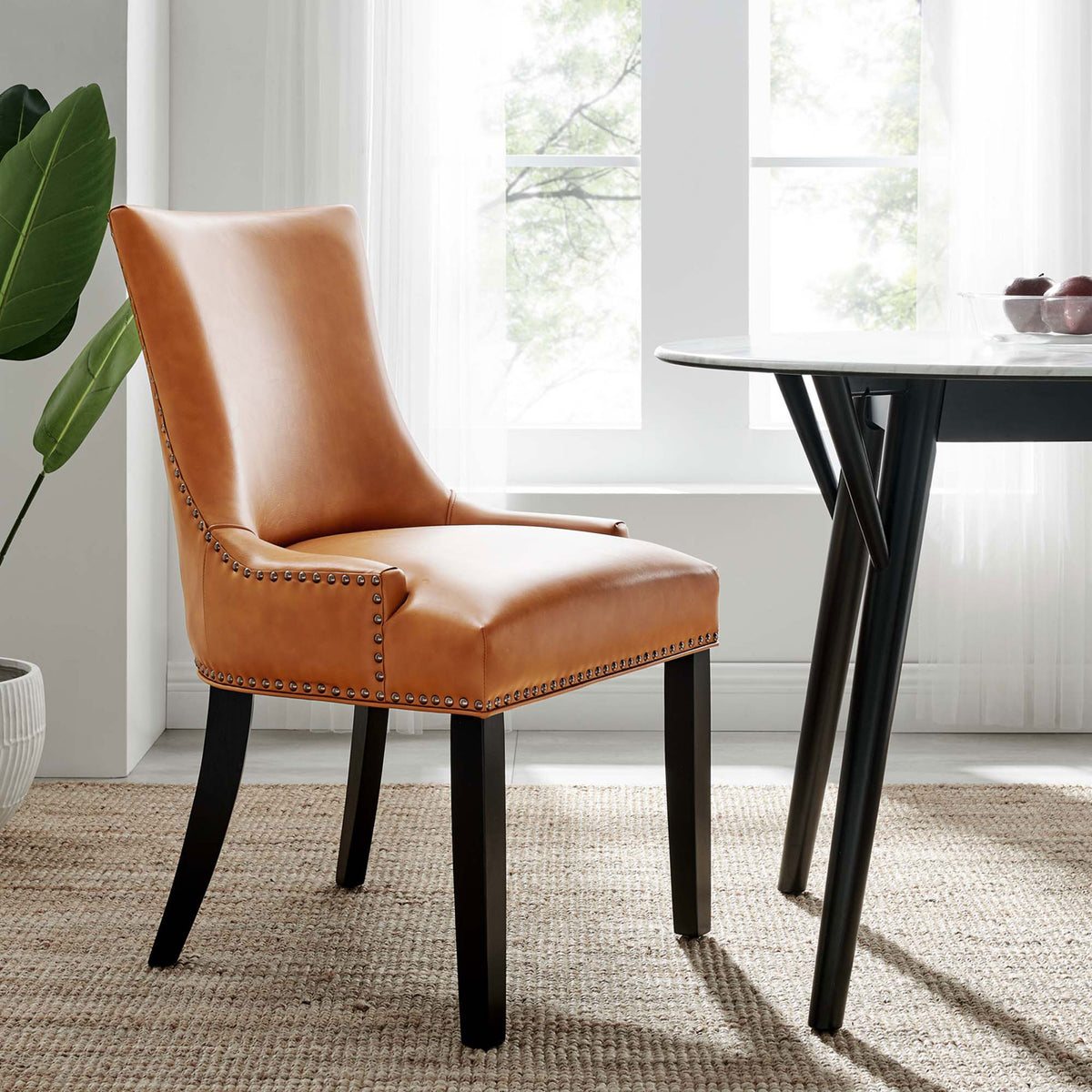 Tan vegan leather dining chair styled by a round dining table in a bright modern room || EEI-2228-TAN || front_angle_room